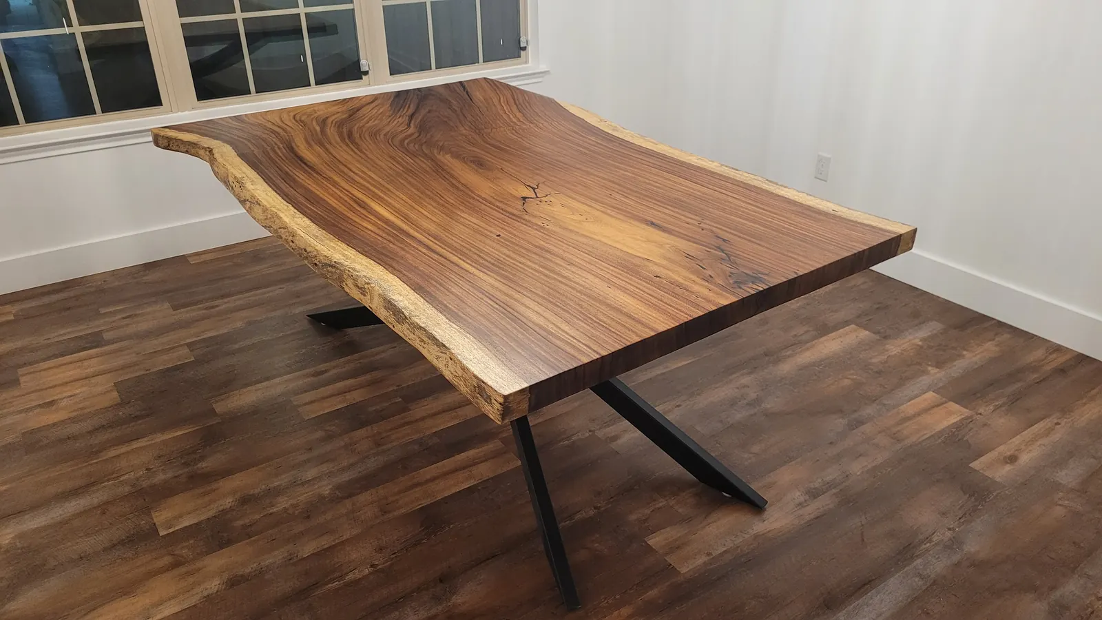 Live edge Guanacaste dining table with X-base in modern room